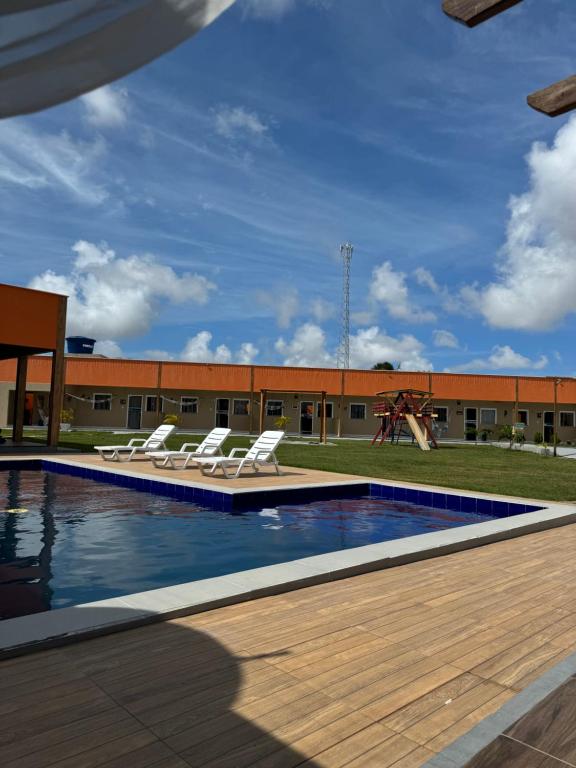 圣阿马鲁Pousada Vila das Lagoas的一个带躺椅的游泳池和游乐场