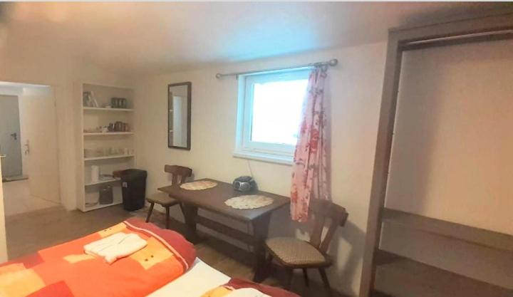 拉肯霍夫Villa Fortuna Budget的一间卧室配有一张床、一张桌子和一个窗户。
