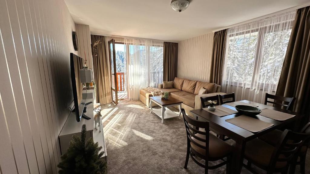 潘波洛沃ELEA Apartment Mountain Lodge Pamporovo的客厅配有桌子和沙发