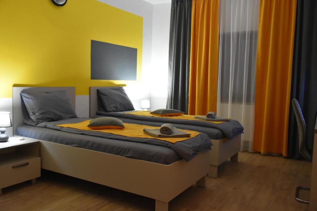 BăicoiCasa Novis的一间卧室设有两张黄色墙壁的床