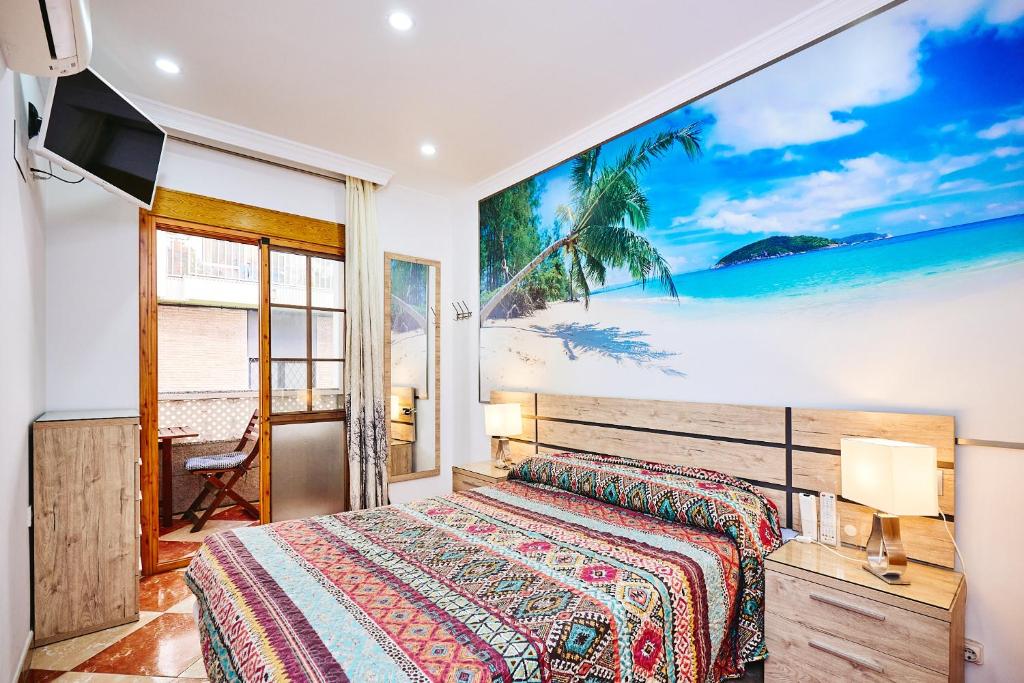 莫切Holidays Beach Torrox - 4的卧室配有一张床,海滩画
