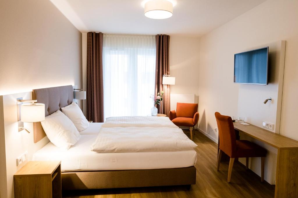汉堡Haus Rissen Gaestehaus的配有一张床和一张书桌的酒店客房