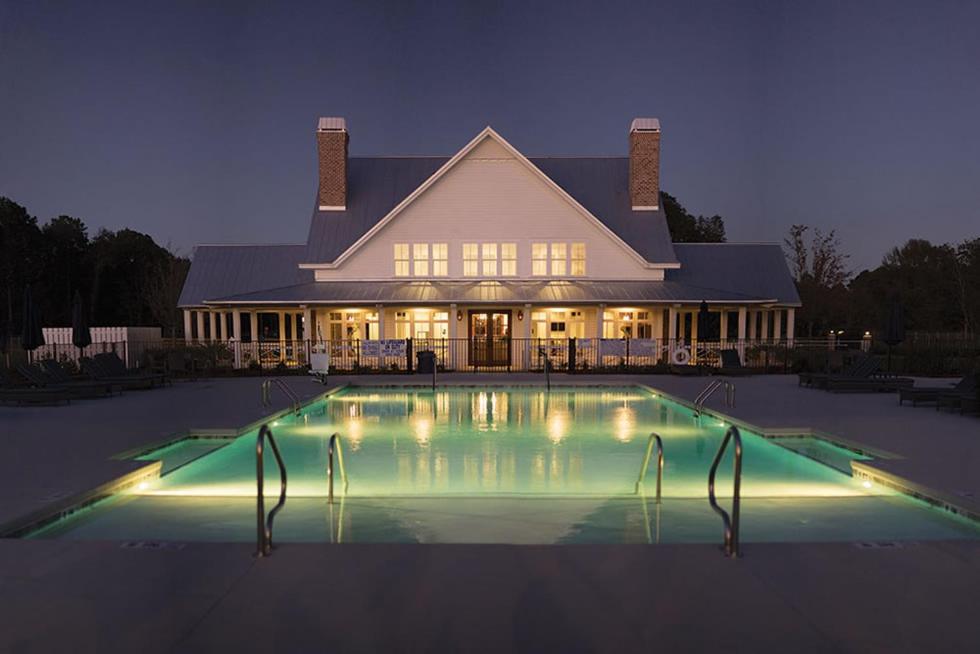 萨凡纳CreekFire RV Resort的一座在晚上设有游泳池的大房子