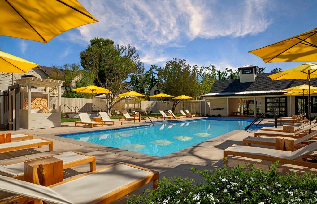 索诺玛麦克阿瑟温泉酒店 的一个带椅子和遮阳伞的游泳池