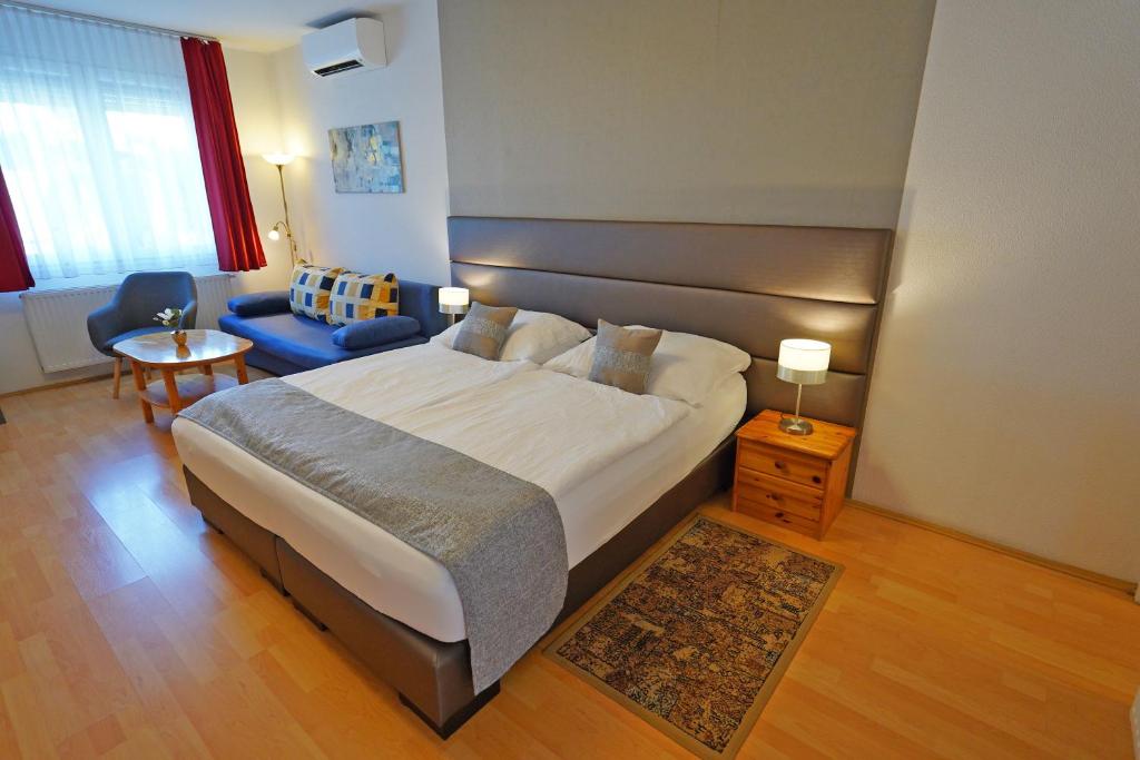 比克碧姬布克法都公寓的一间卧室配有一张大床和一张蓝色的沙发