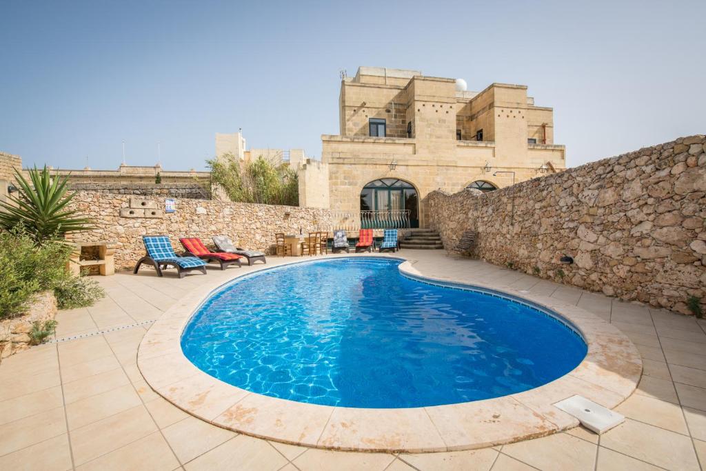 纳杜尔3 Bedroom Farmhouse with Private Pool & Views in Nadur Gozo的石头建筑前的游泳池