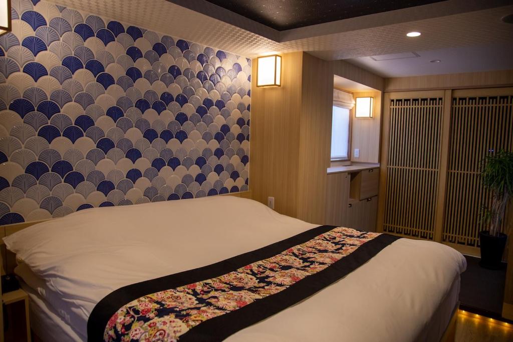 东京Hotel Opera的一间卧室配有一张带图案墙壁的床