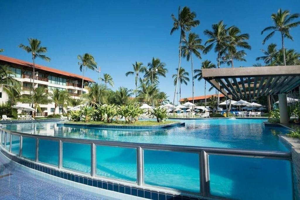 嘎林海斯港Marulhos Suites Resort的棕榈树度假村的游泳池