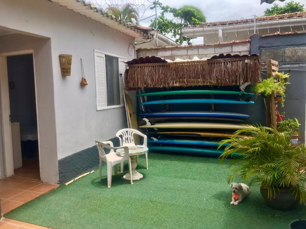 伯迪亚哥SURFuncional Guest House的坐在房子前面绿色地毯上的狗