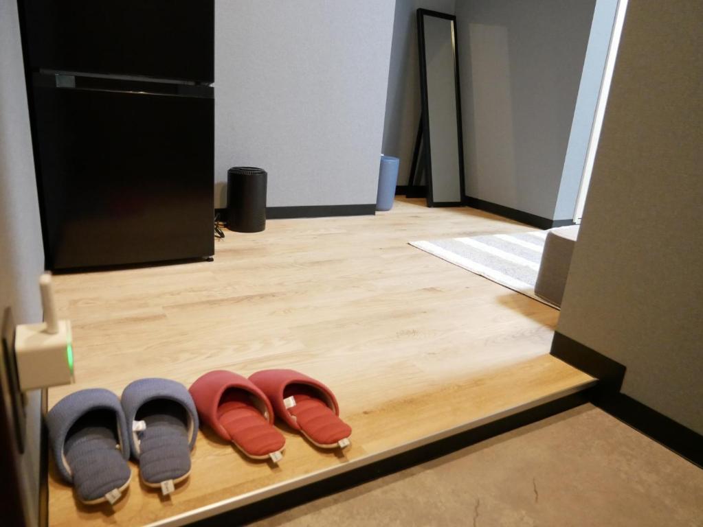 奄美HOOD - Vacation STAY 46041v的坐在木地板上的一排鞋子