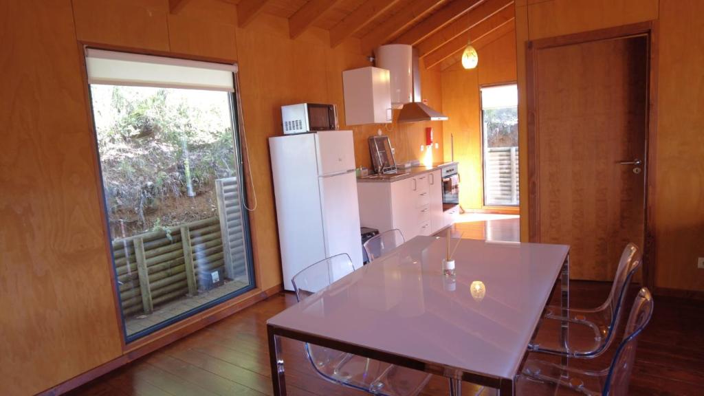 布拉干萨Sobre Aguas Camping的厨房配有桌子和白色冰箱。