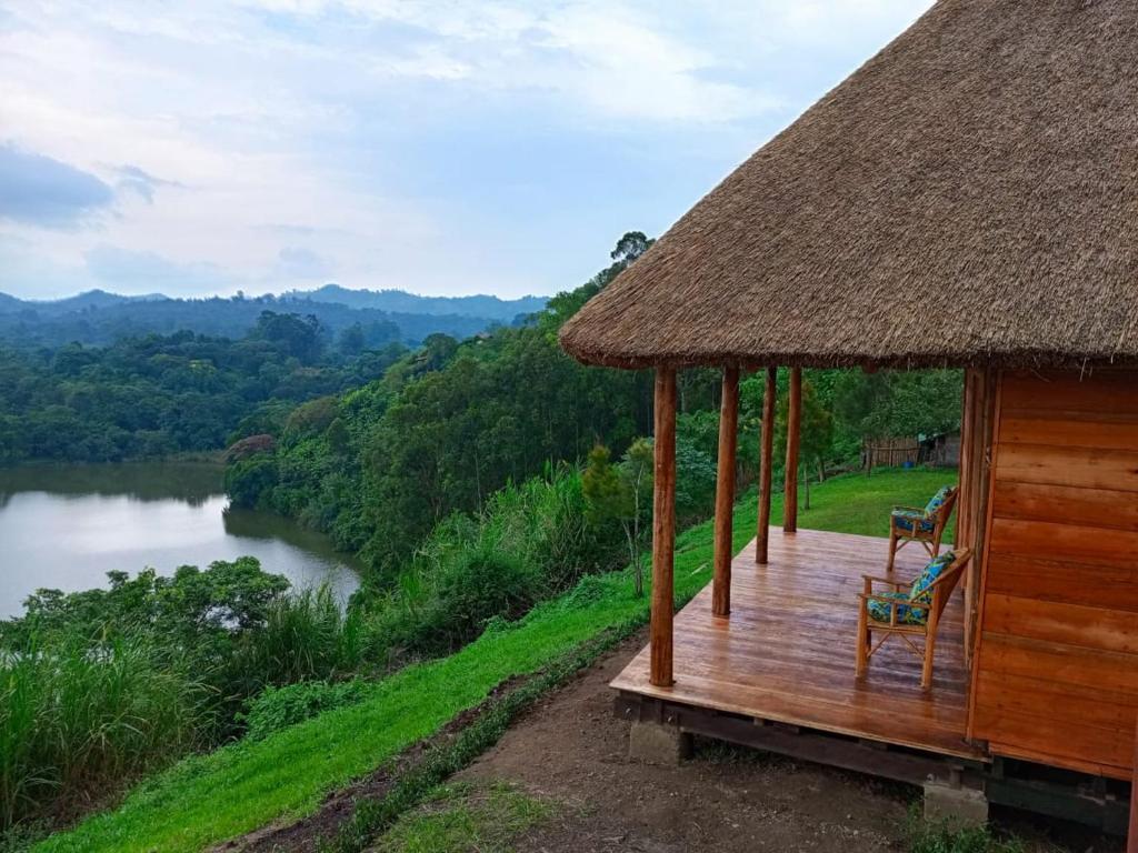 波特尔堡Mwamba Kelele Lodge的河边甲板上的小屋,配有两把椅子
