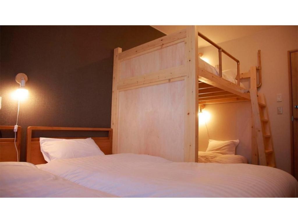 稚内THE STAY WAKKANAI - Vacation STAY 40685v的一间卧室配有两张床和一张双层床。