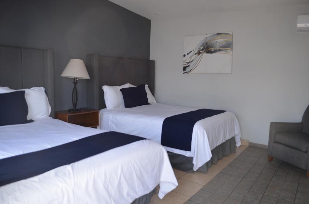 恩塞纳达港Hotel CASA PETRI的酒店客房,配有两张床和椅子
