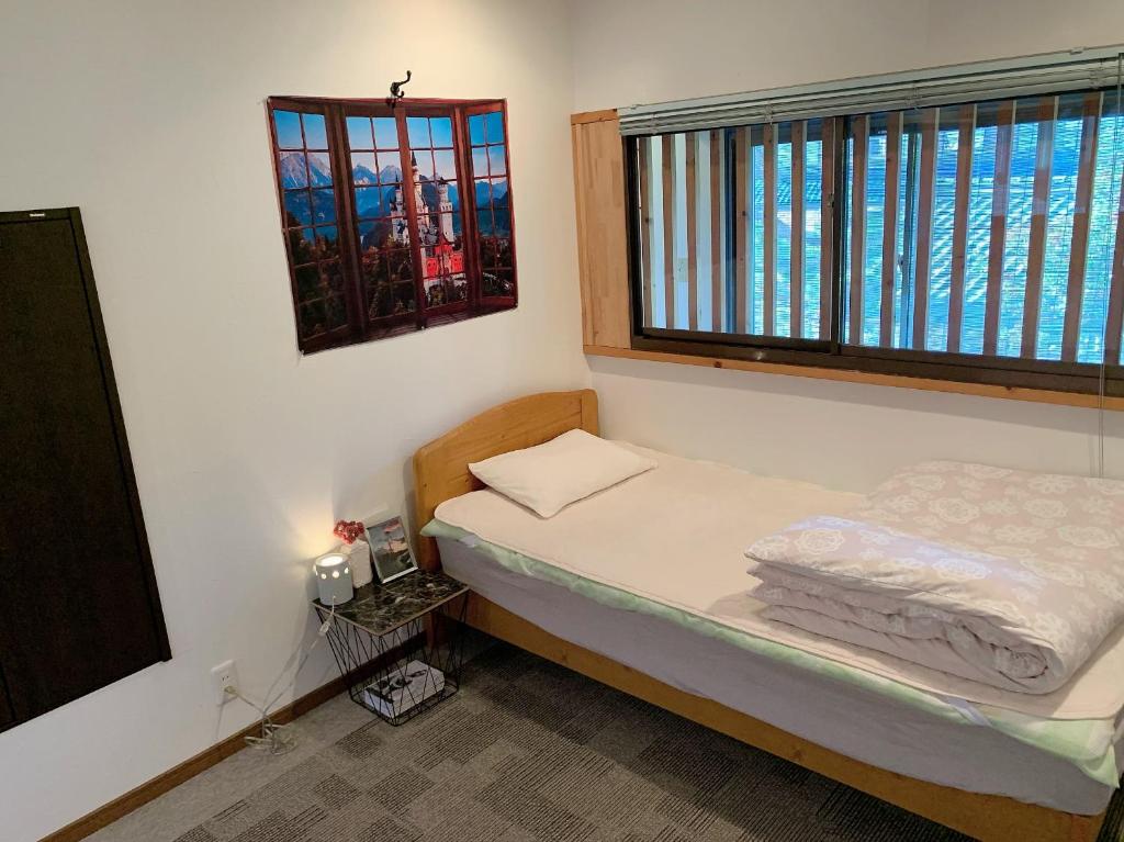 端岛Guesthouse Hope的一间小卧室,配有床和2个窗户