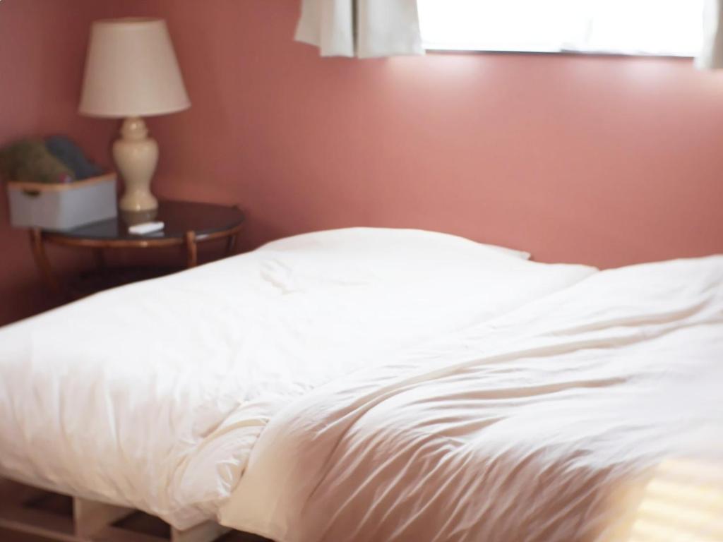 五岛Goto - House - Vacation STAY 66191v的卧室内的一张白色床,桌子上配有一盏灯