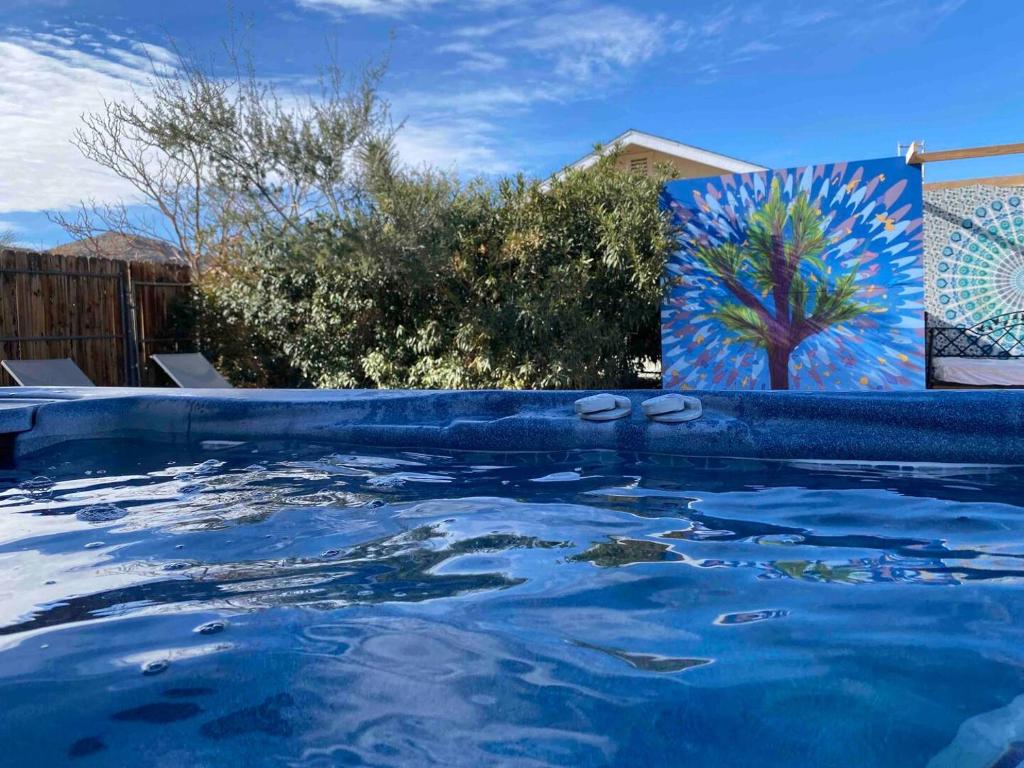 约书亚树Electroliquid&#39;s Casa Pueblo Joshua Tree的一座游泳池,上面画着一棵树