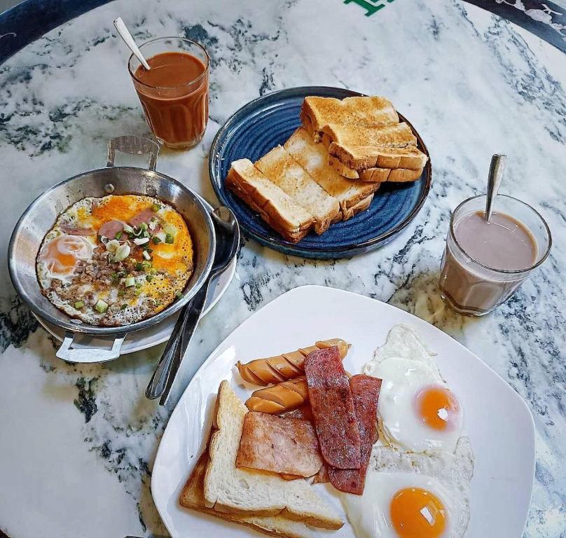 勿洞SUNZI BOUTIQUE HOSTEL : ซันซิ บูทีค โฮสเทล的一张桌子,上面放着一盘早餐食品和烤面包