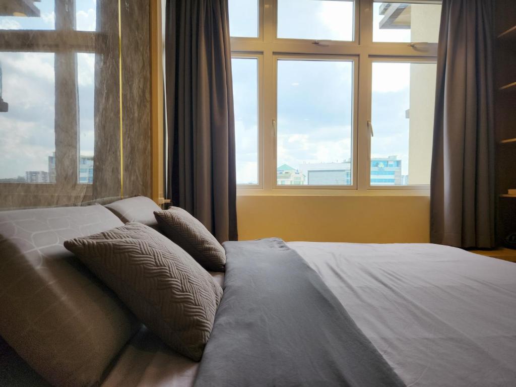 古晋Kuching City Centre Smart Home Luxury Resort Condo的窗户客房内的一张带枕头的床