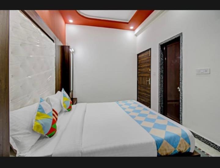 乌代浦7horses holidays homes的卧室配有白色的床和色彩缤纷的枕头