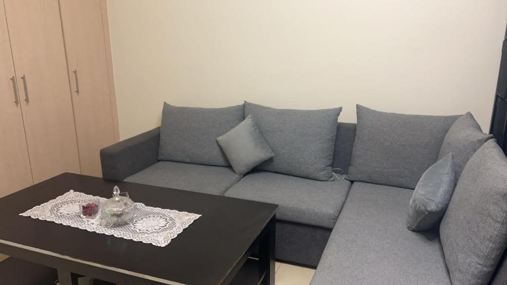 迪拜Al badaa的客厅配有灰色的沙发和桌子