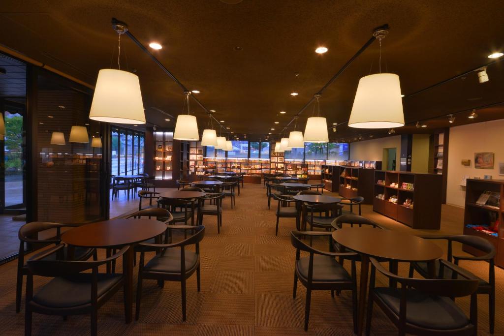 京都嵯峨岚山比纳里奥酒店的用餐室配有桌椅和灯光