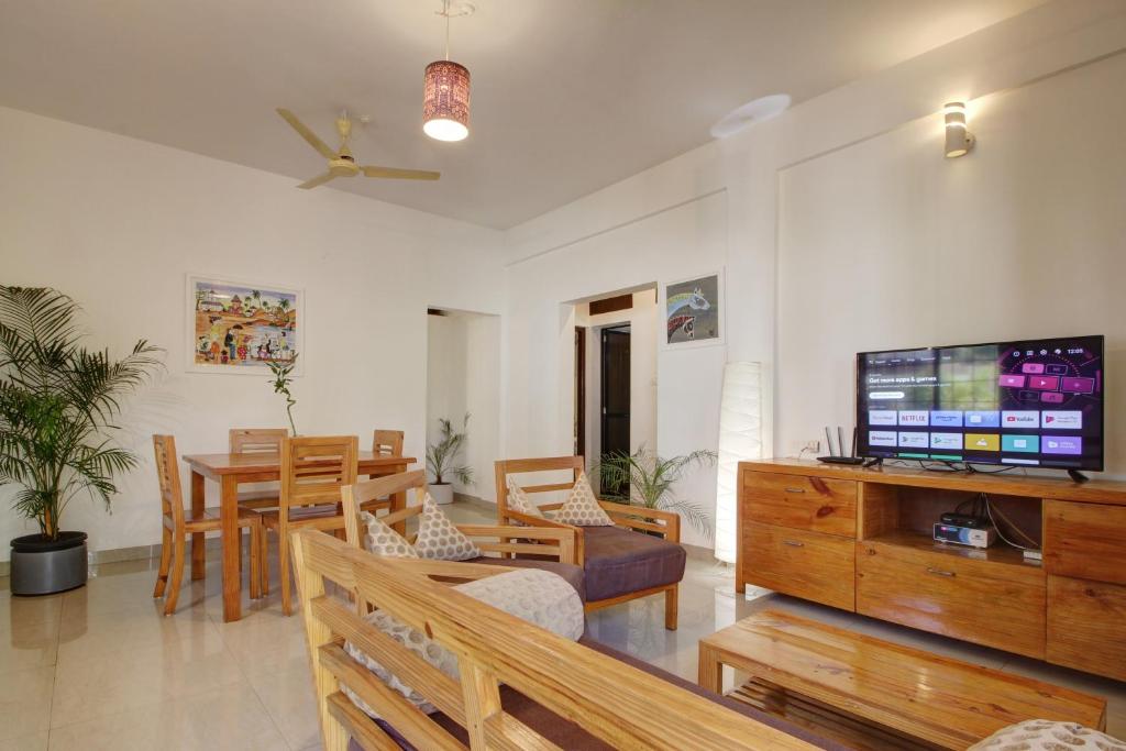 马普萨Genesis Abode - Cosy 2 BHK Bungalow in Assagao的带电视的客厅和用餐室