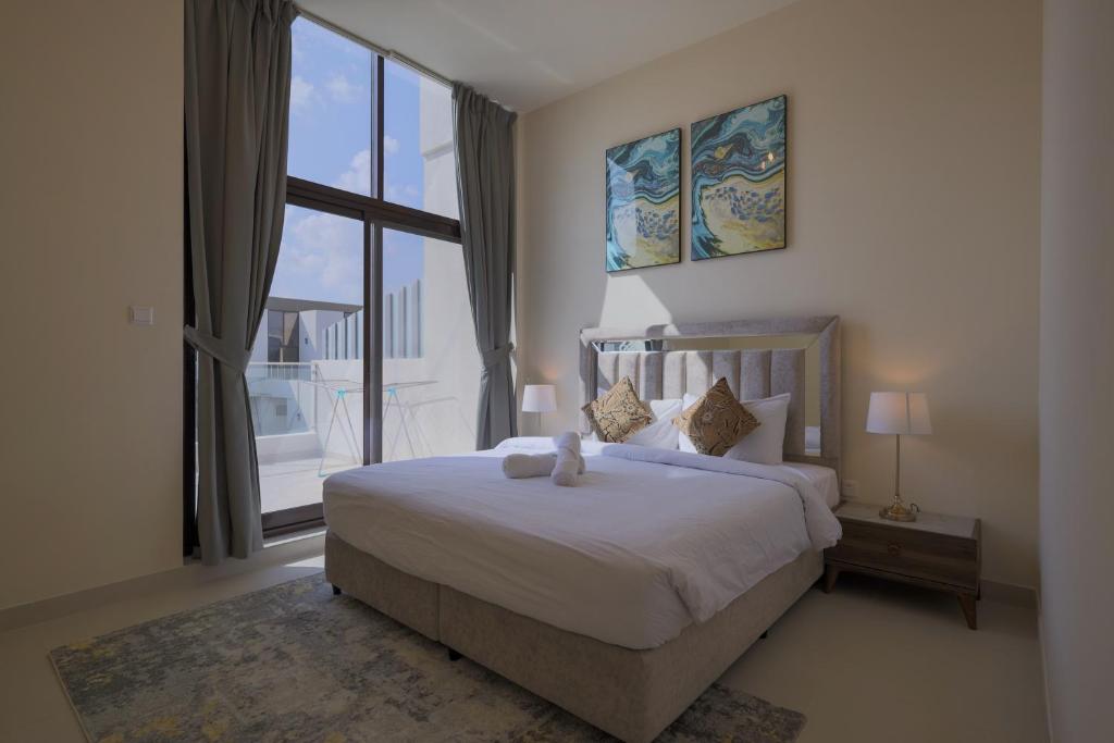 迪拜Fabulous 4br villa with Balcony的一间卧室设有一张大床和一个大窗户