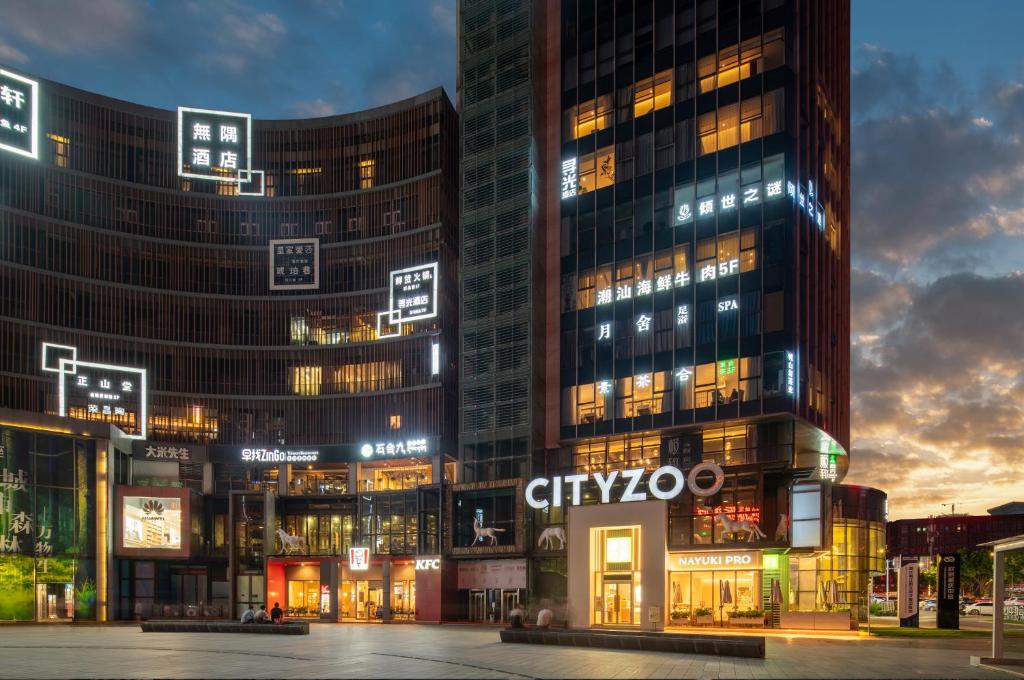重庆寻光酒店(重庆两江幸福广场店)的一群高大的建筑在晚上在城市里