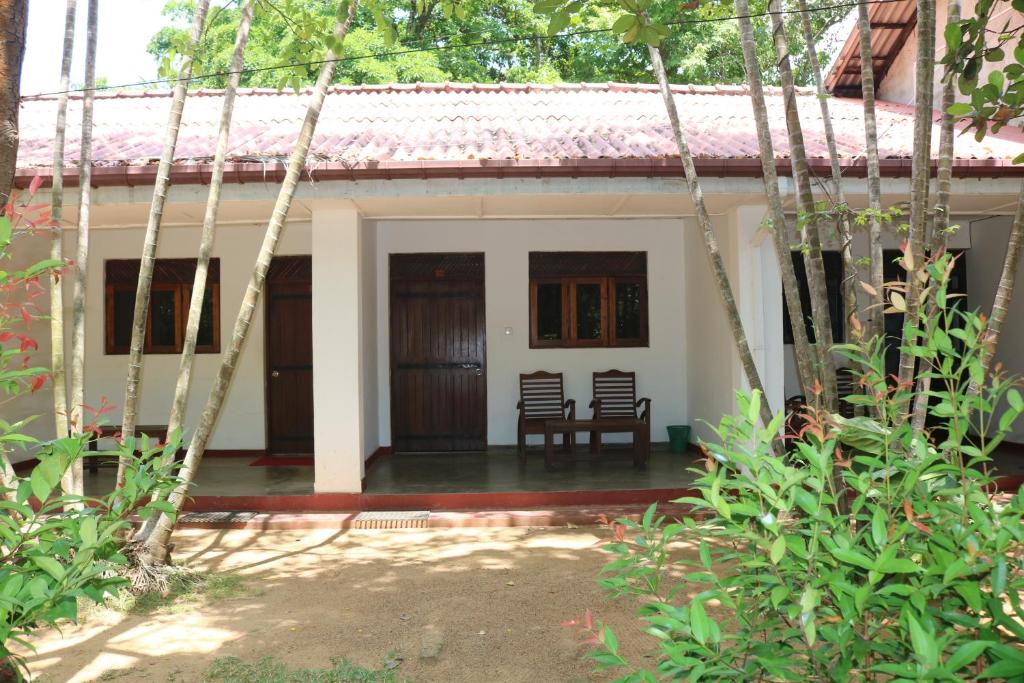 波隆纳鲁沃Polonnaruwa Holiday Inn的前面有两把椅子的房子