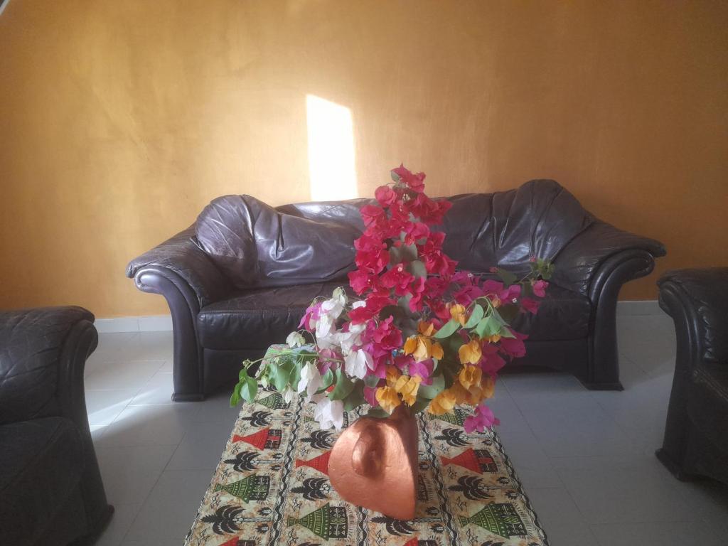 济金绍尔Appartement familial spacieux avec climatisation的花瓶,花在桌子上,长沙发