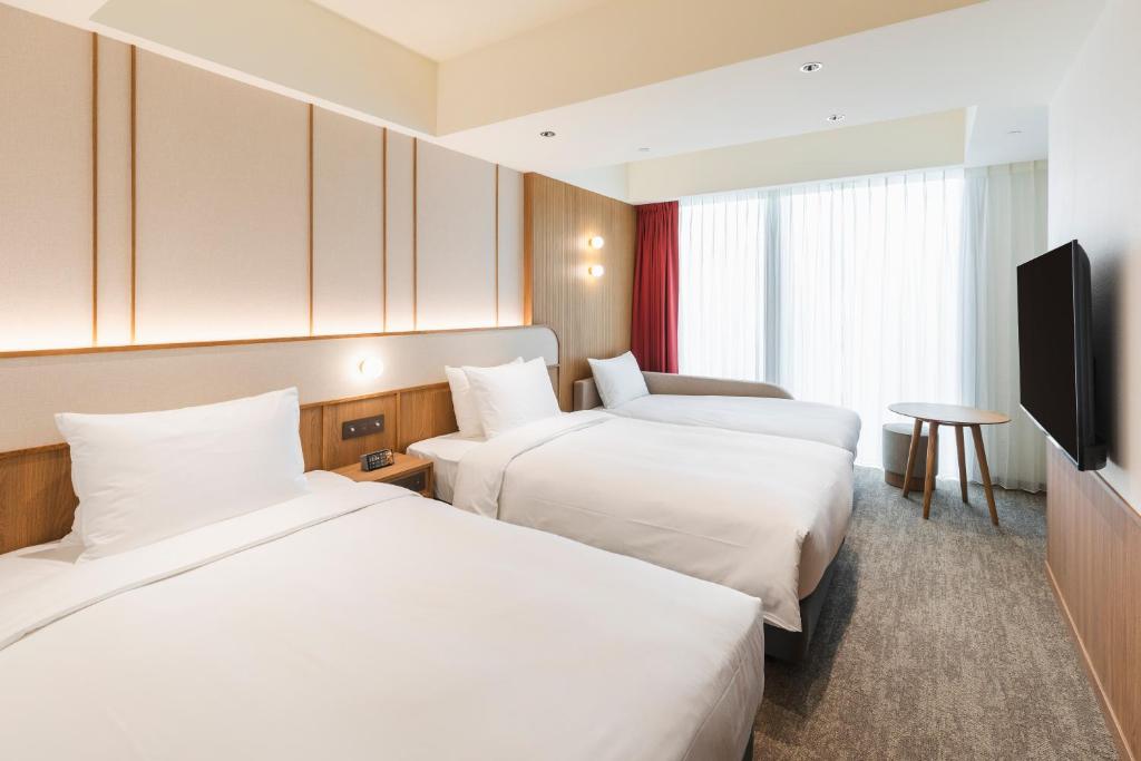 台北相铁饭店台北西门的酒店客房设有两张床和一台平面电视。