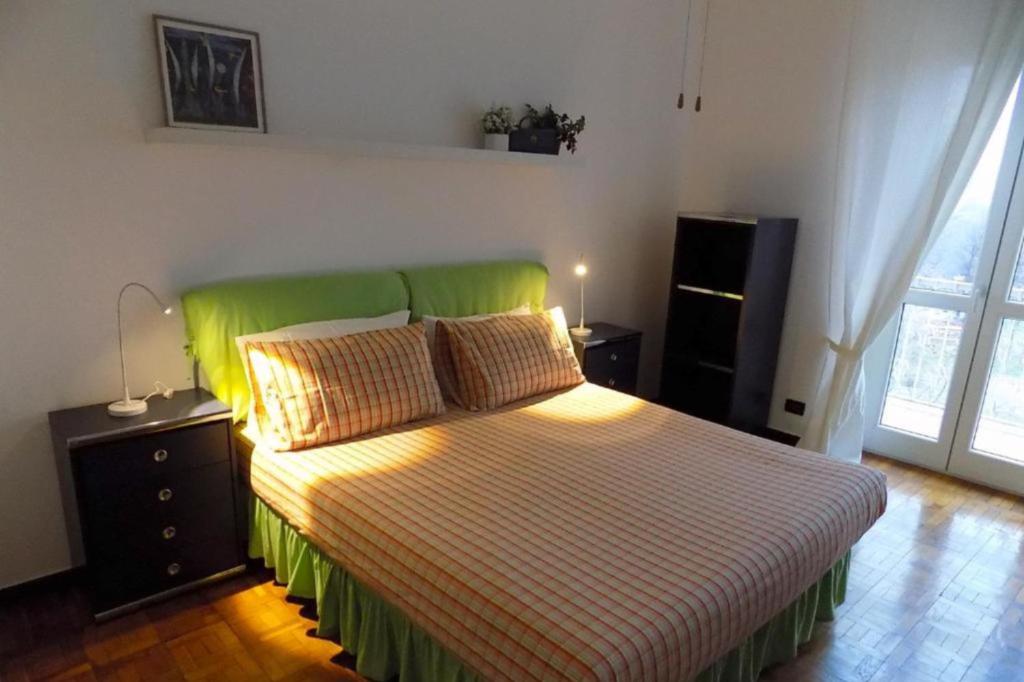 都灵Atriums Apartment Massaua的一间卧室配有一张带绿色床头板的床