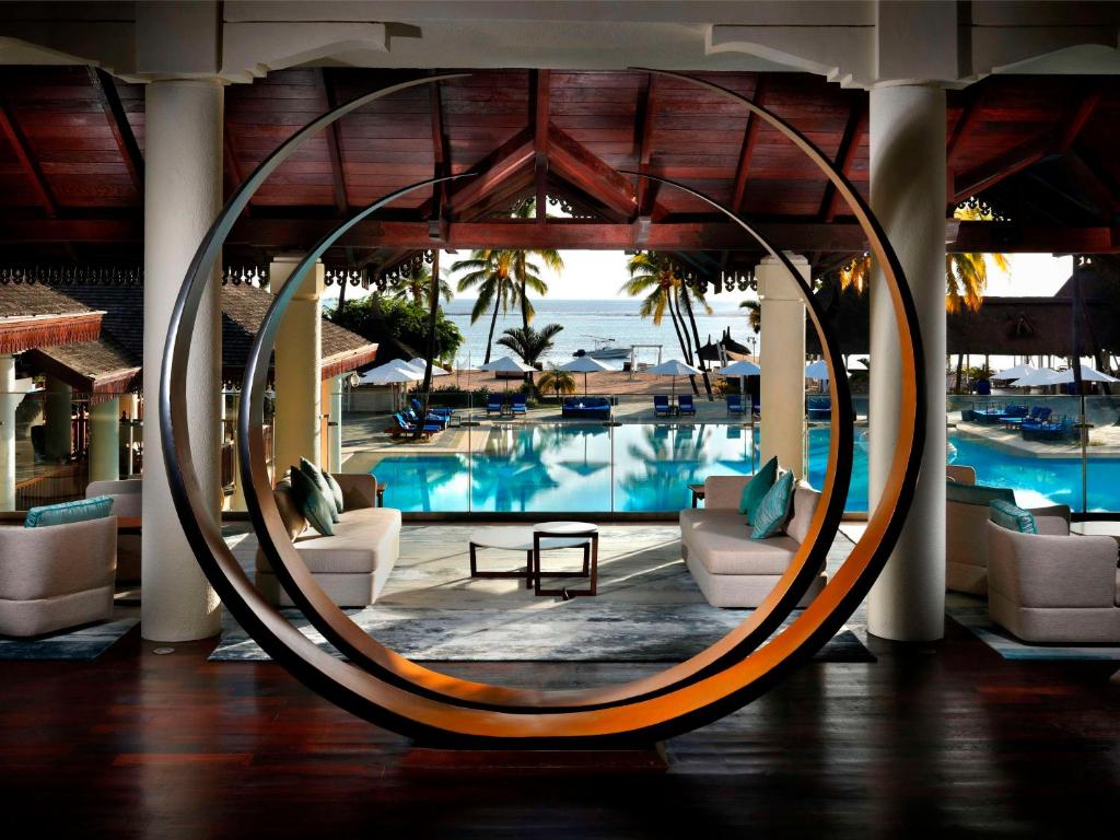 弗利康弗拉克Sofitel Mauritius L'Imperial Resort & Spa的酒店大堂设有游泳池、椅子和桌子