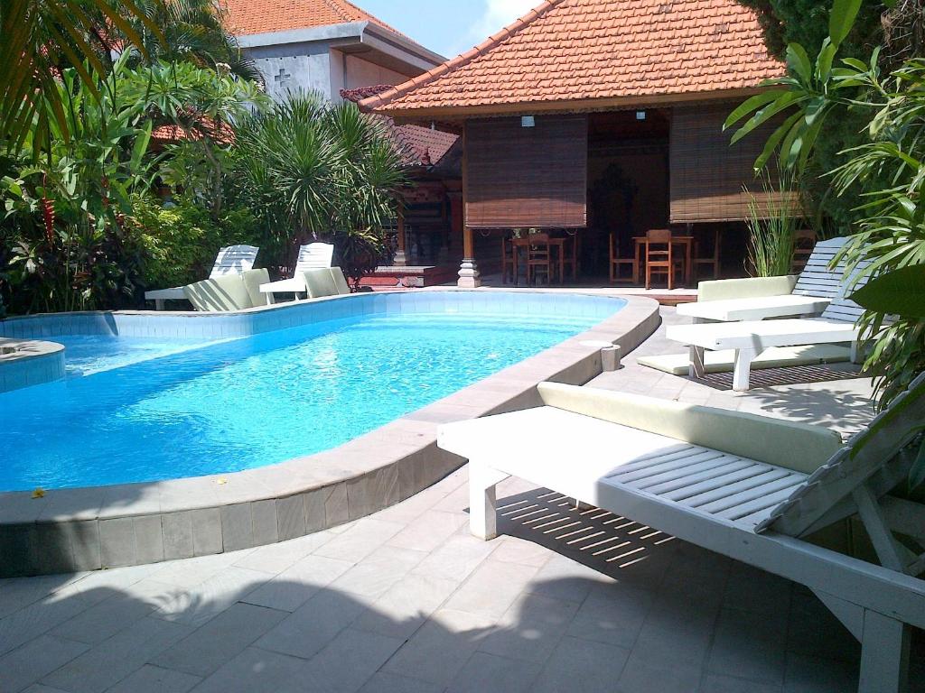 勒吉安阿杜斯海滩酒店的游泳池周围设有躺椅和椅子