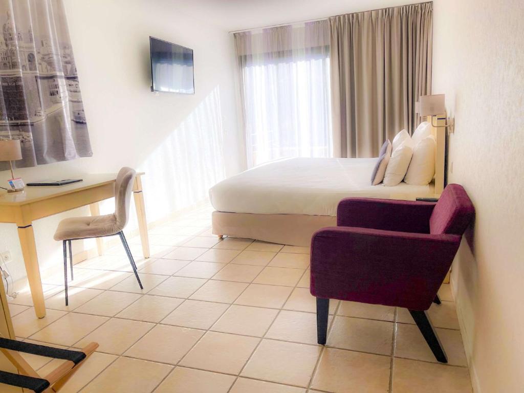热姆诺普罗旺斯吉蒙诺斯贝斯特韦斯特酒店的酒店客房配有一张床、一张桌子和一把椅子。