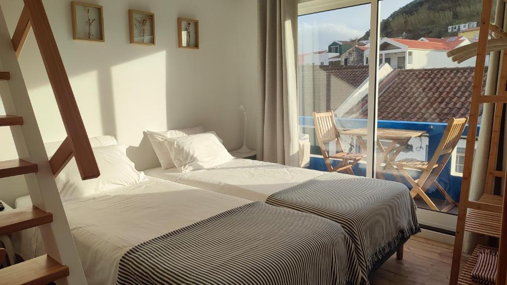 奥尔塔Porto Pim Guest House的一间卧室设有一张床和一个美景阳台