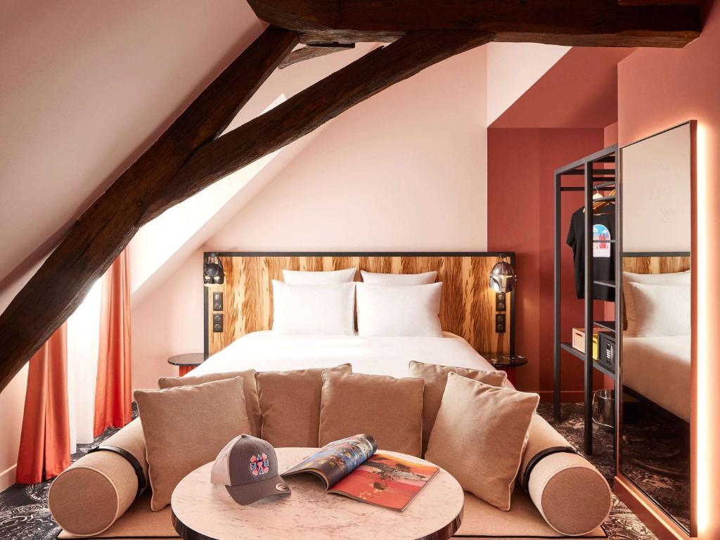 雷恩Mama Shelter Rennes的一间卧室配有一张床和一张带桌子的沙发
