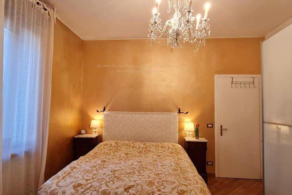 维罗纳Luxury Verona Apartment City Centre的一间卧室配有一张床和一个吊灯