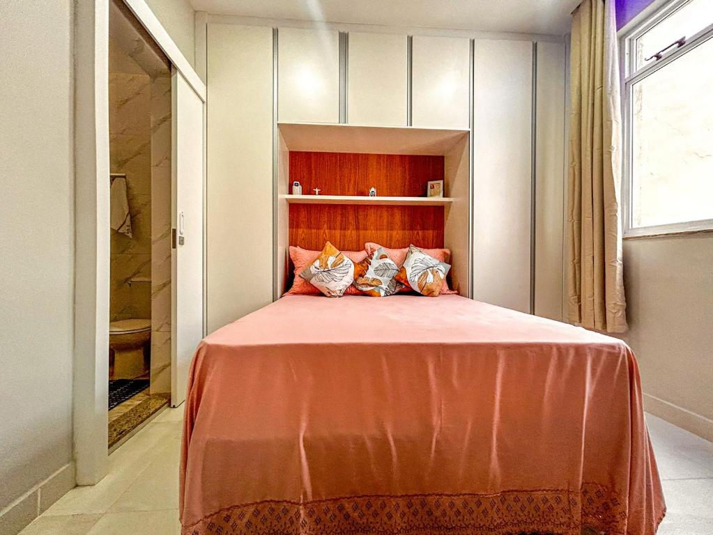 里约热内卢Ótimo studio c WiFi a 190m da Praia do Leme - RJ的一间卧室配有带橙色床单和枕头的床。