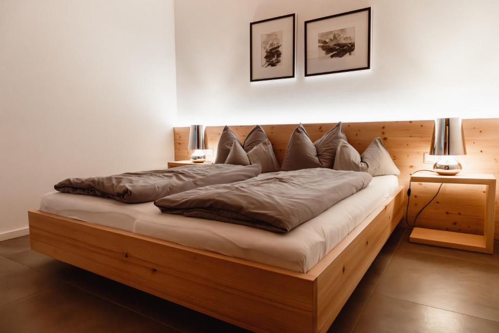 安纳贝格-伦格茨ALPINE LOFT Martini的一间卧室配有一张带枕头的大型木制床。