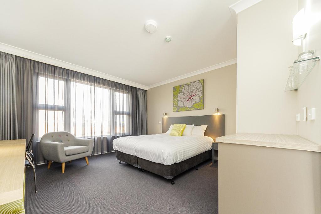 考拉考拉服务俱乐部汽车旅馆的配有一张床和一把椅子的酒店客房