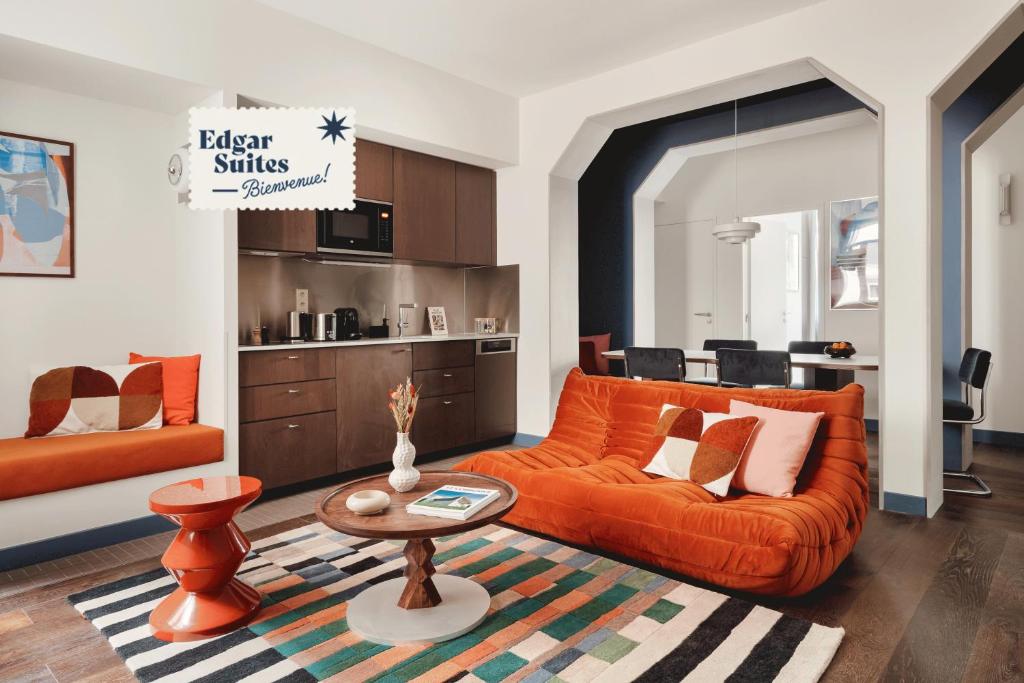 里尔Edgar Suites Lille - Faidherbe的客厅配有橙色沙发和桌子