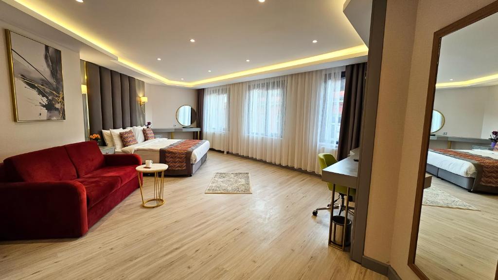伊斯坦布尔The Külsümz Hotel的酒店客房配有红色的沙发和床。
