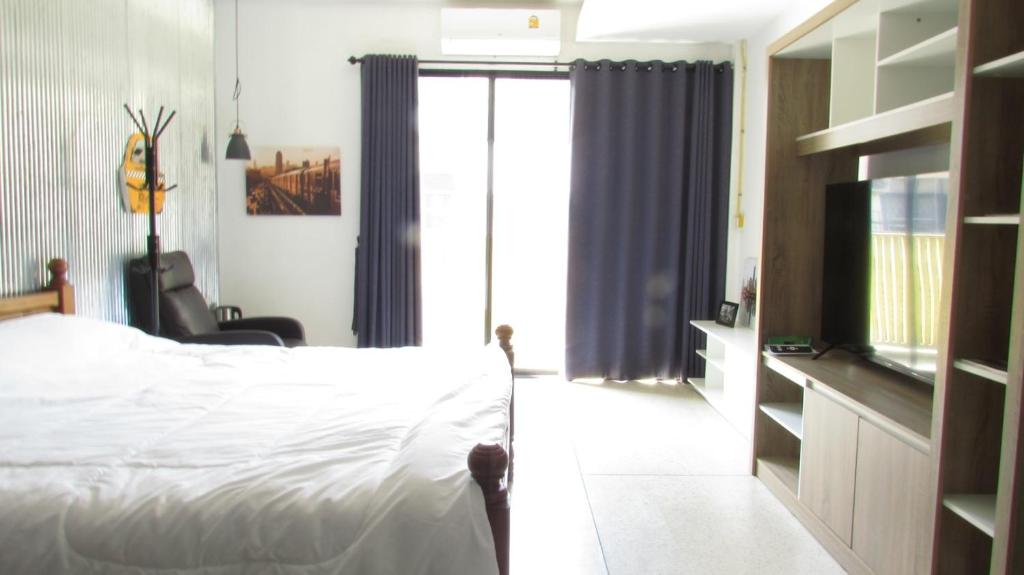 清迈Reconnecting的一间卧室设有一张床和一个滑动玻璃门