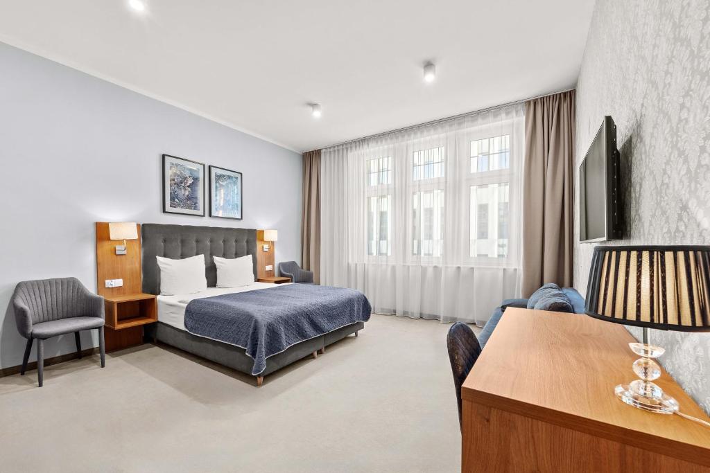 弗罗茨瓦夫Brassel Aparthotel的配有一张床和一张书桌的酒店客房