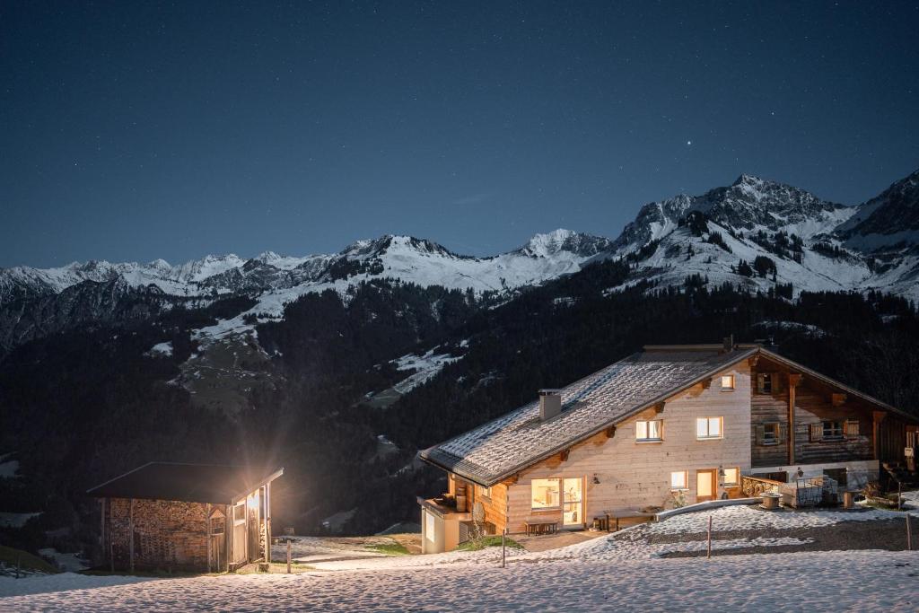 丰塔内拉Chalet Frederik的雪中的一个小木屋,晚上有山