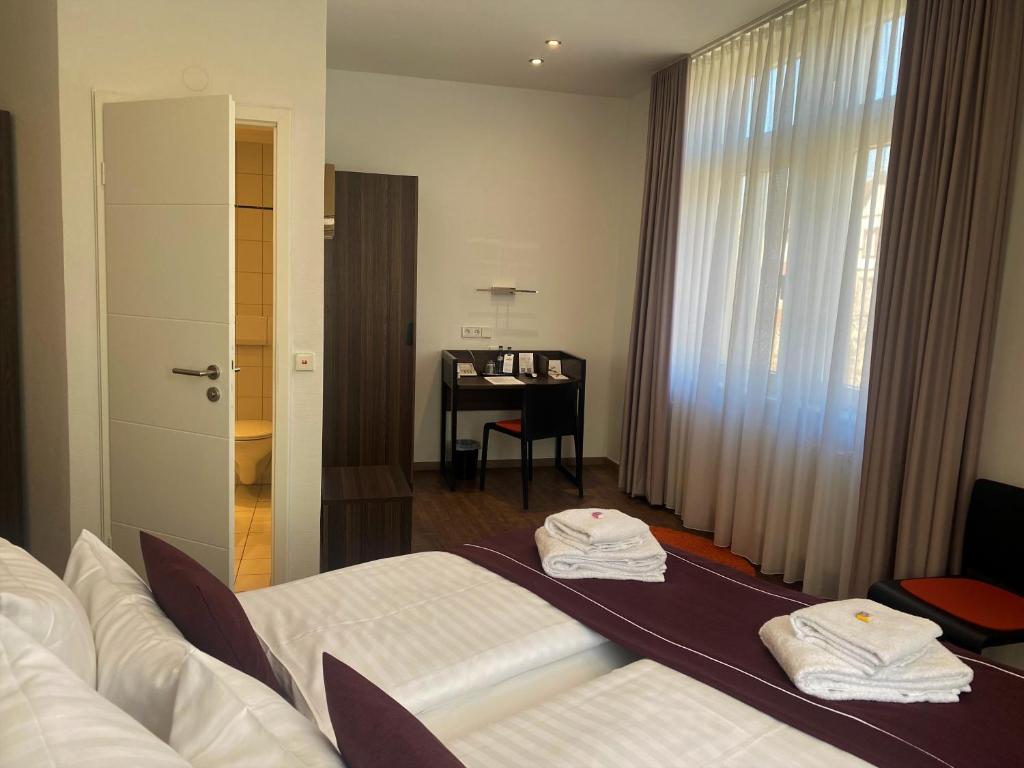 卡尔斯鲁厄sevenDays Hotel Karlsruhe的一间酒店客房,配有一张床和一张书桌