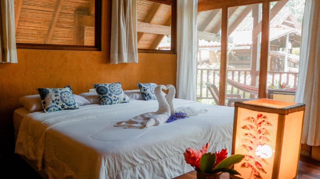 塔拉波托Canto del Río Lodge的一间卧室配有一张带天鹅的床