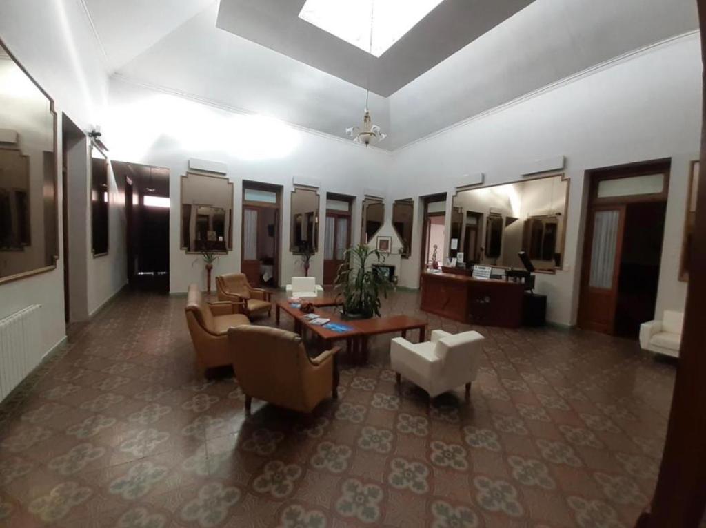 乌拉圭河畔康塞普西翁HOTEL LOURD MARY的带沙发、桌子和镜子的大客厅